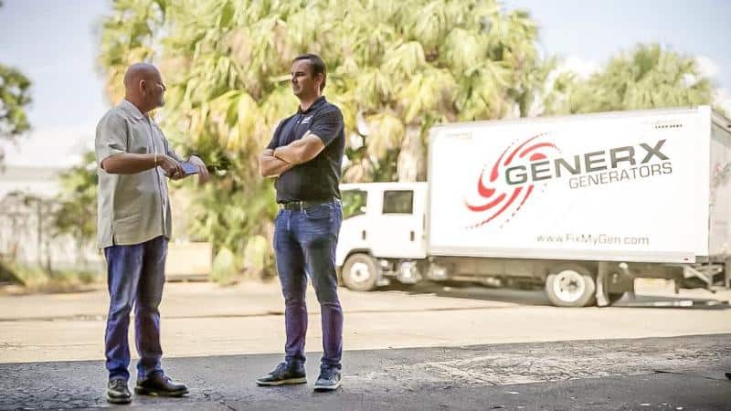 Two men talking beside a GenerX Generators box truck